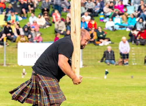 Competitor straining in weight for height throw at 2023 games