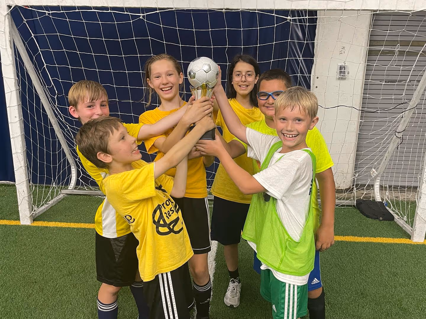 The Sports Factory Camps - kids holding a trophy for winning world cup day!