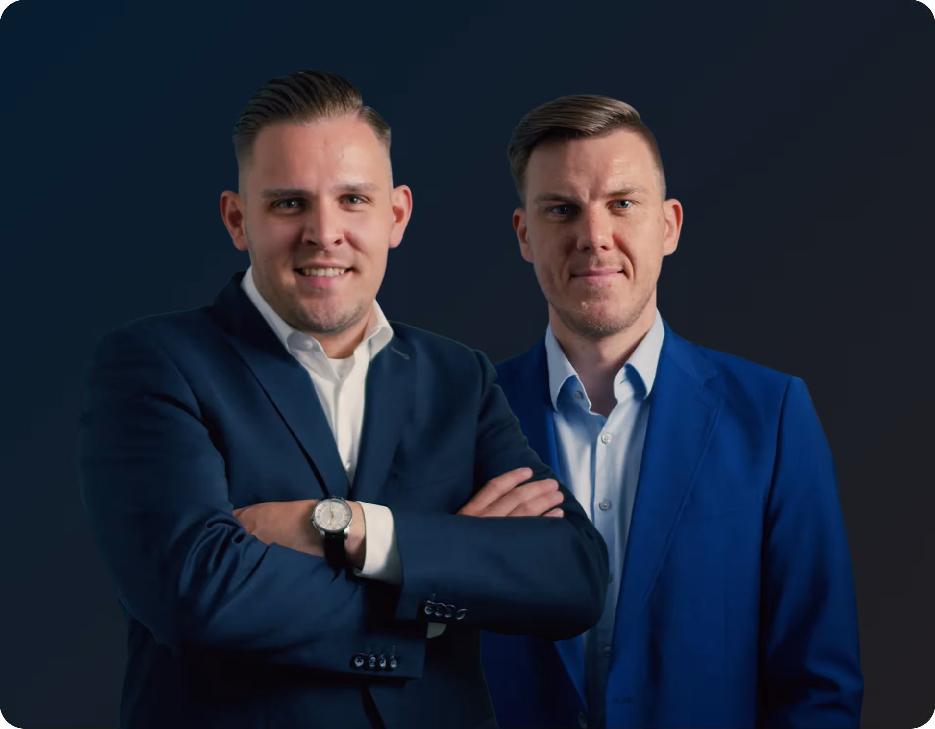 Zwei Männer in Anzügen vor dunklem Hintergrund, einer mit verschränkten Armen und Uhr am Handgelenk.