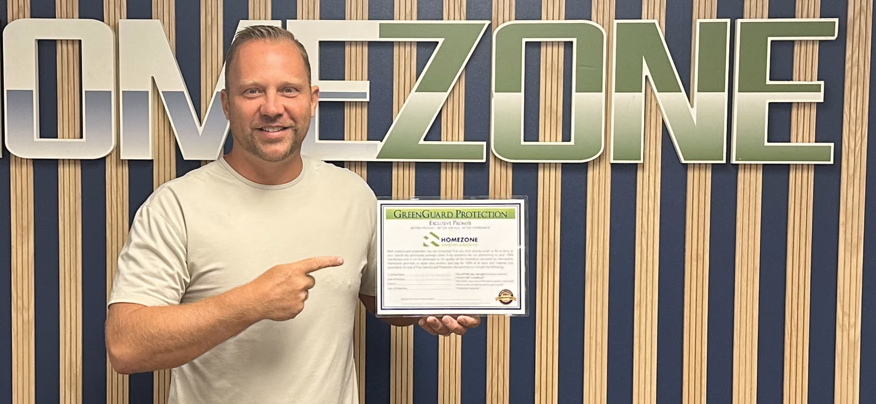 Done Wyper, Homezone owner holding the Greenguard Protection Certificate provided by Homezone.