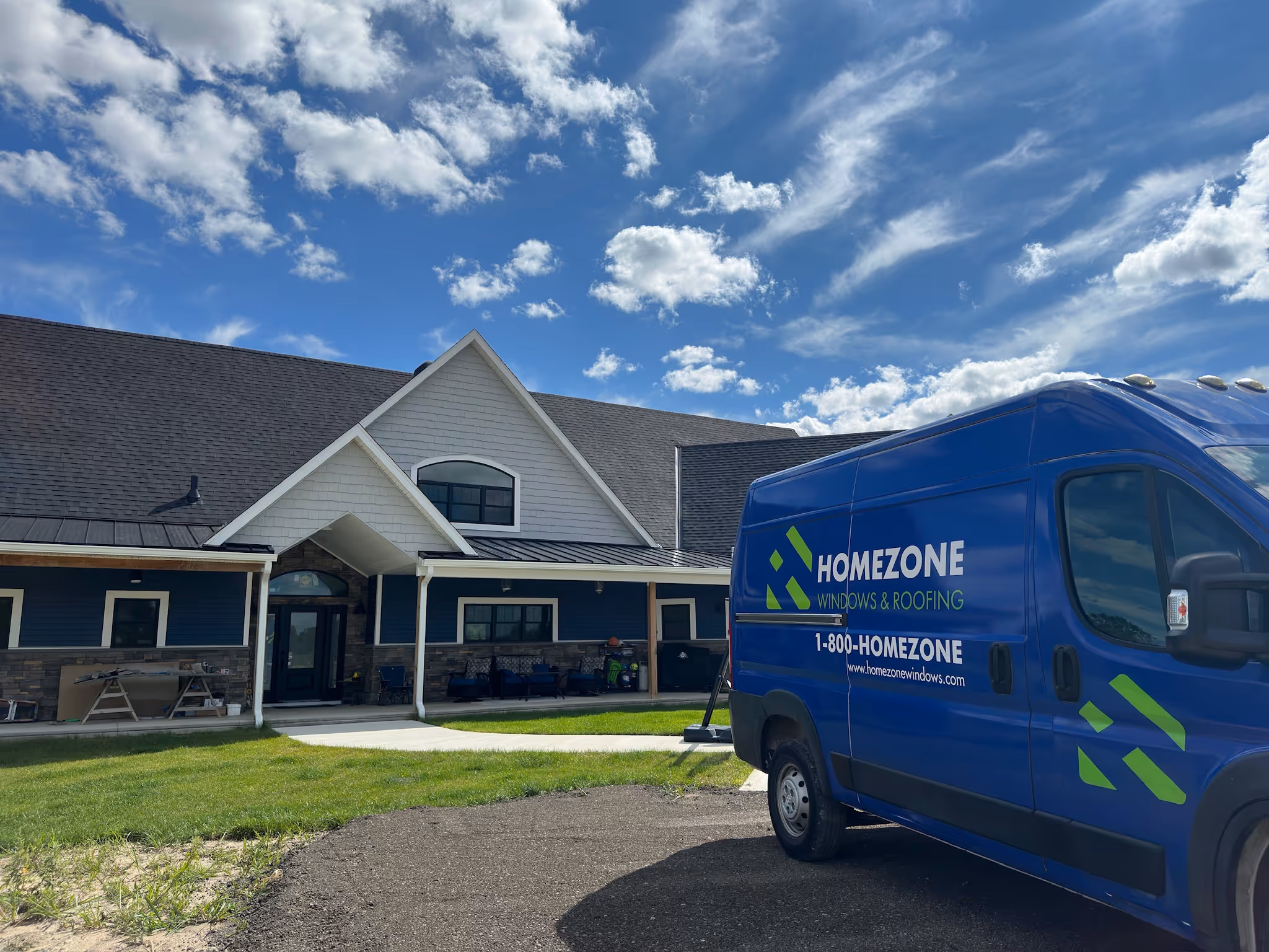 Homezone Crew Standing Outside a Home with New Asphalt and Metal Roof Installed