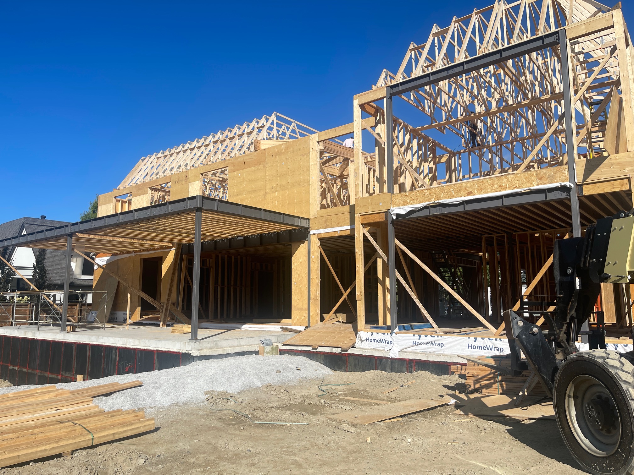 Custom home rear view in Vaughan, Ontario showing steel beam installation and roof trusses framing