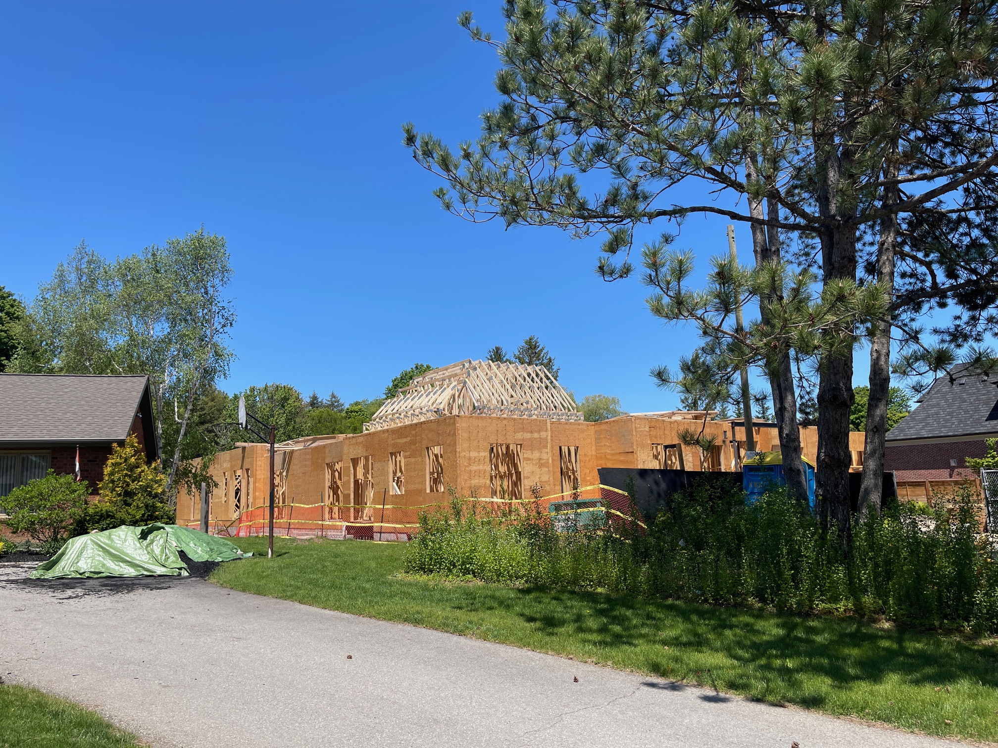 Framed walls completed with roof trusses being installed on 6,000 sq ft custom bungalow in King City, Ontario