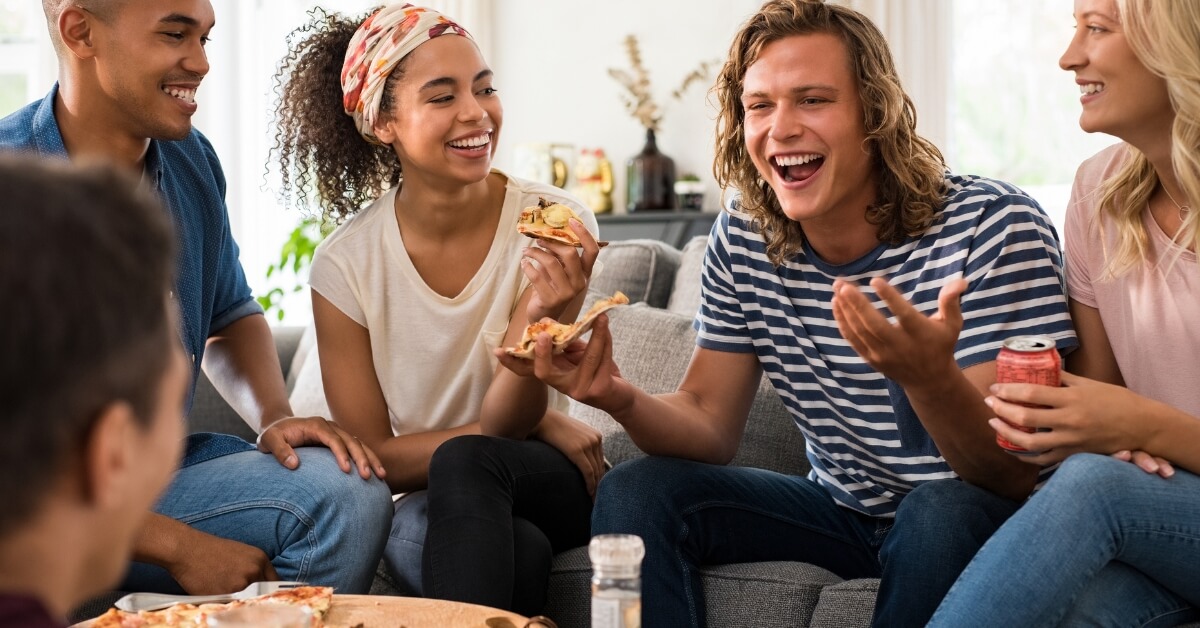 Groupe d’amis partageant une pizza dans une ambiance conviviale