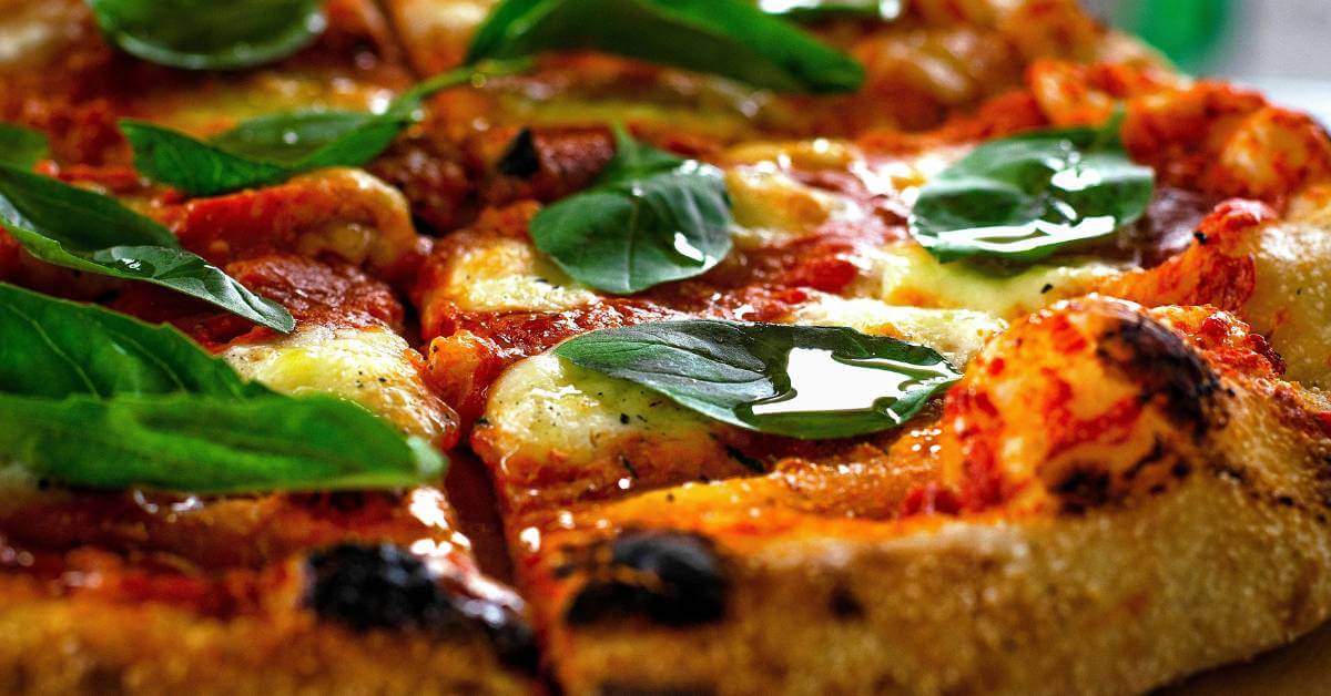Pizza romaine dorée à la semoule, croûte croustillante et basilic frais – résultat d’un empattement au blé dur.