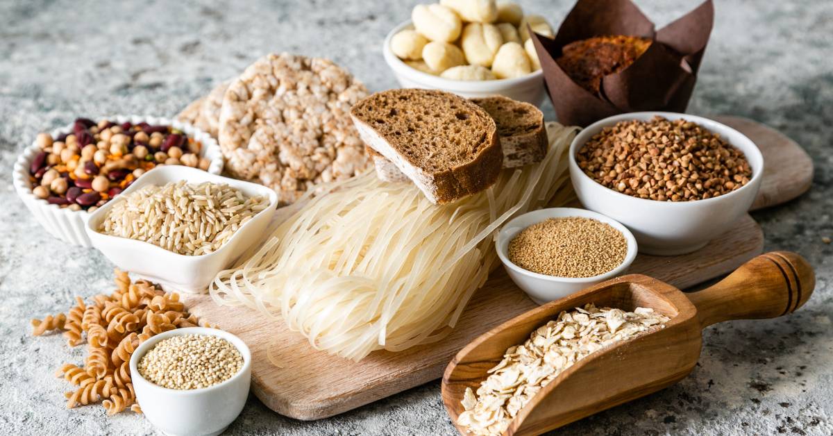 Sélection de farines et aliments sans gluten comme le riz, le sarrasin et le maïs, utilisés pour préparer une pizza sans gluten maison.