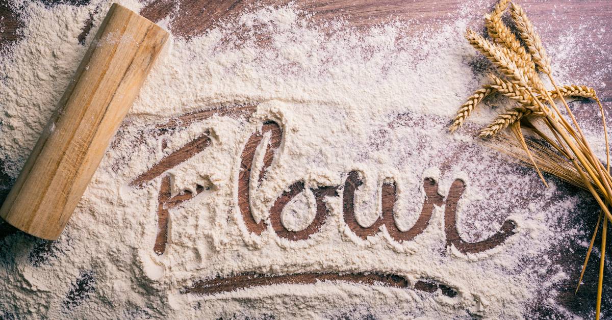 Farine blanche pour pâte à pizza artisanale sur un plan de travail en bois