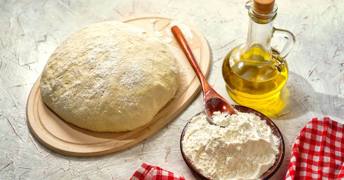 Ingrédients pour pâte à pizza maison avec farine, huile d’olive et pâte prête à fermenter