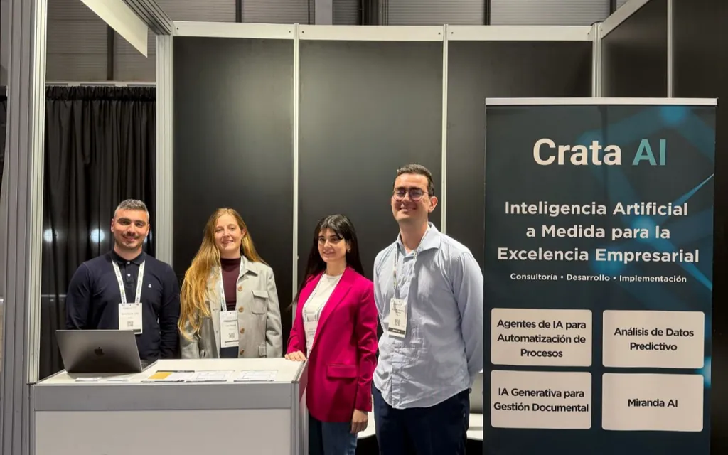 Four people smiling behind a booth with Crata AI banner about AI solutions for business excellence.
