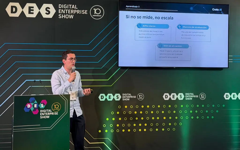 Man presenting on stage at Digital Enterprise Show with a slide titled 'Si no se mide, no escala.'