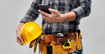 majstor koji drži kacigu i telefon