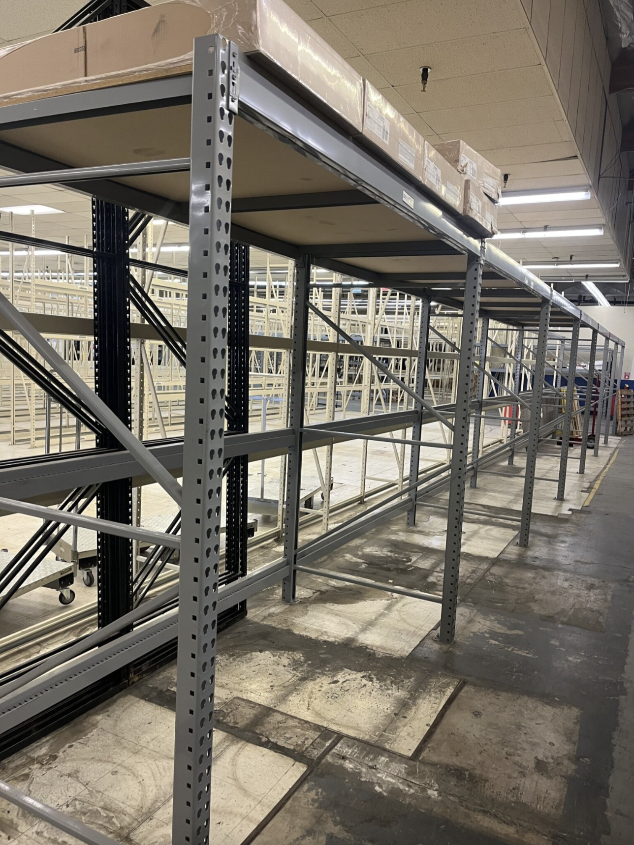 Grey teardrop pallet racking system with upright frames and horizontal beams, ideal for industrial warehouse storage solutions