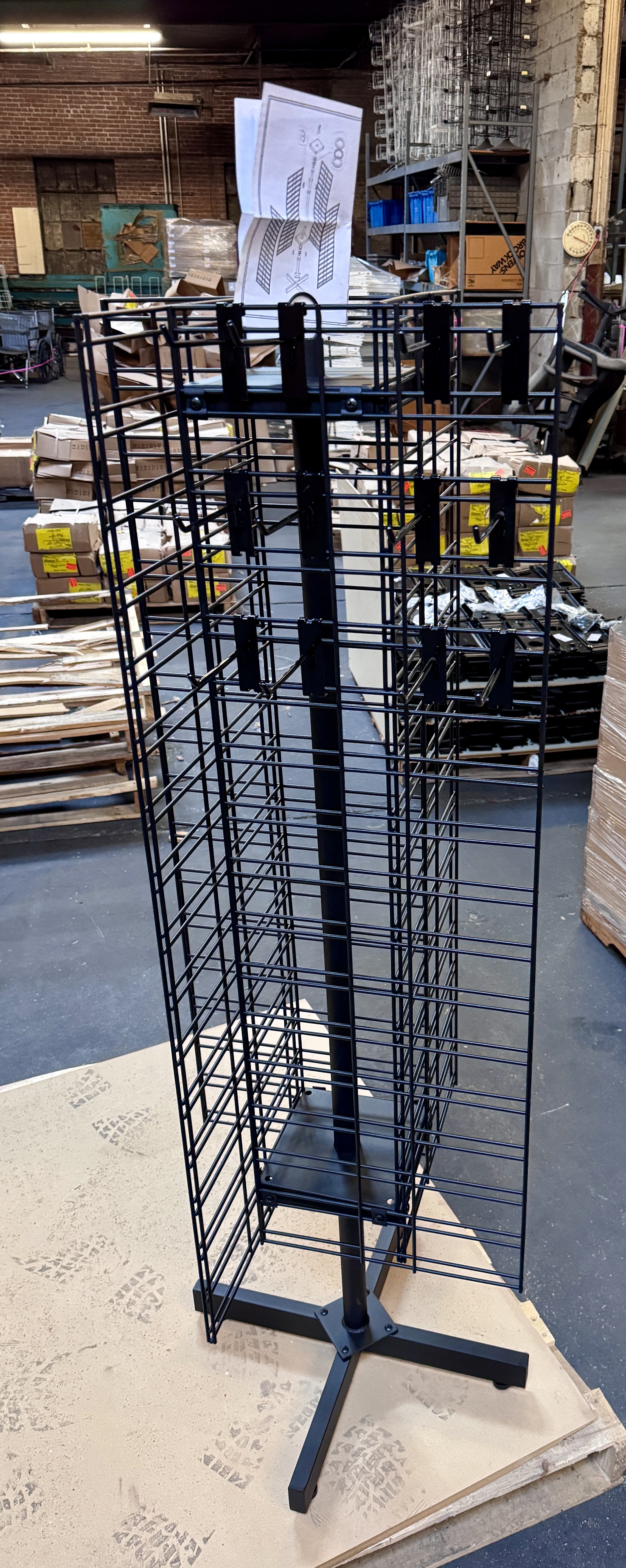 Black wire rotating jewelry spinner rack with multiple peg hooks for accessories and small merchandise. Retail spinner display racks available from Mid-America Store Fixtures.