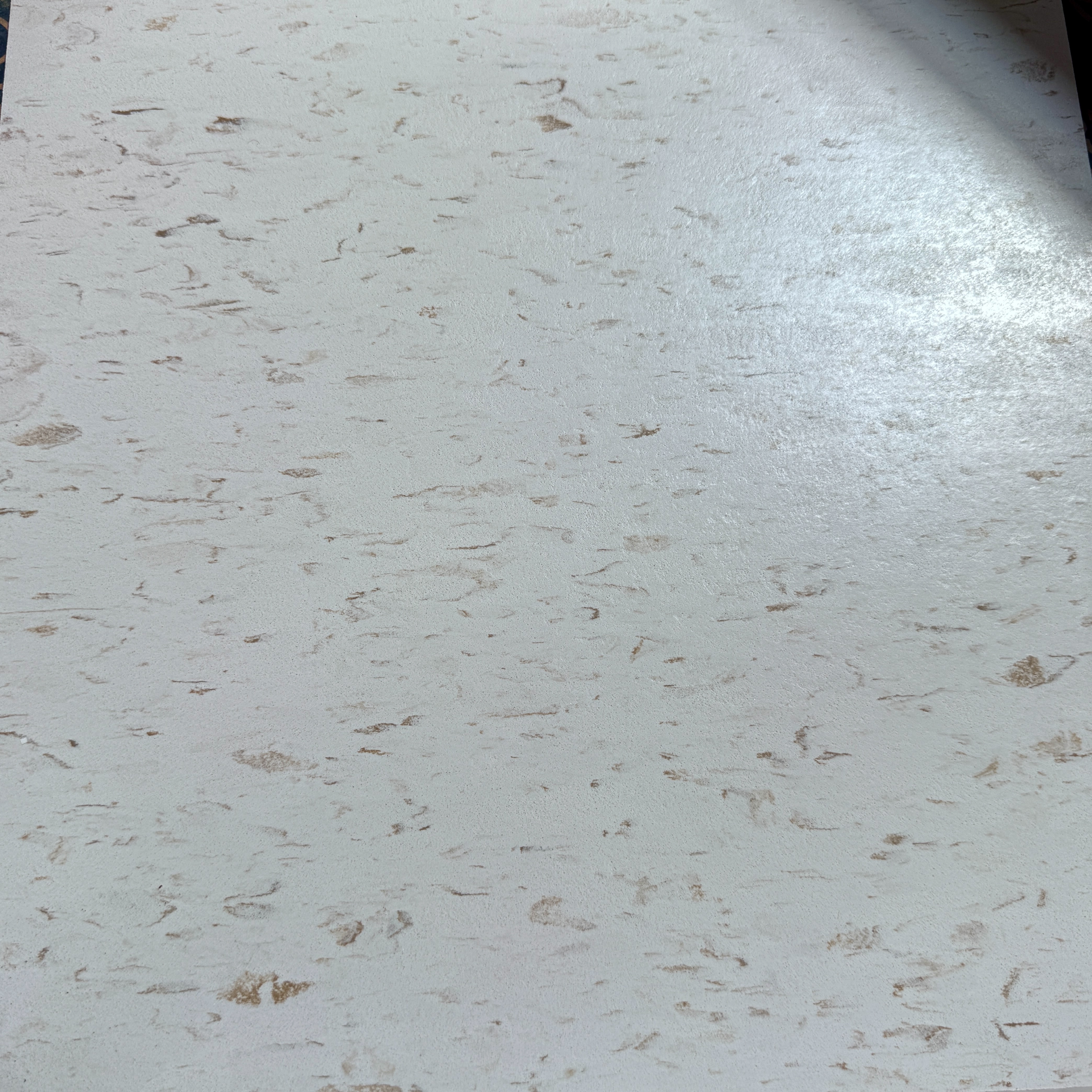 Close-up of commercial 12x12 vinyl composite tile with light beige and tan marbled pattern, ideal for retail stores, grocery floors, and commercial facilities. Vinyl flooring available from Mid-America Store Fixtures.