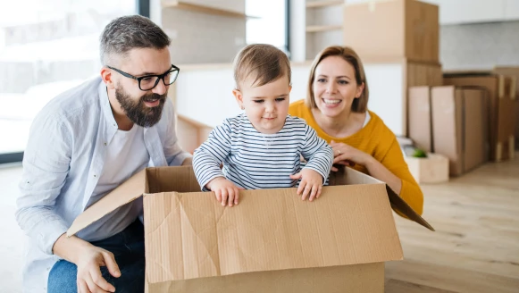 A baby playing in a moving box in his family's new house.