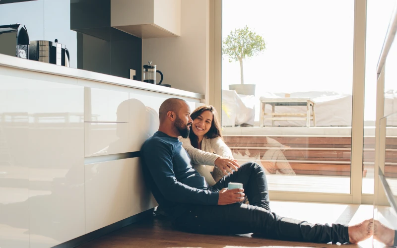 First time homebuyers enjoying a coffee in the kitchen of their new home.