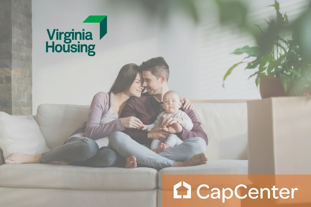 An image of a young couple sitting on the couch of their new home, purchased using a Virginia Housing DPA program.