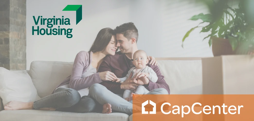 An image of a young couple sitting on the couch of their new home, purchased using a Virginia Housing DPA program.