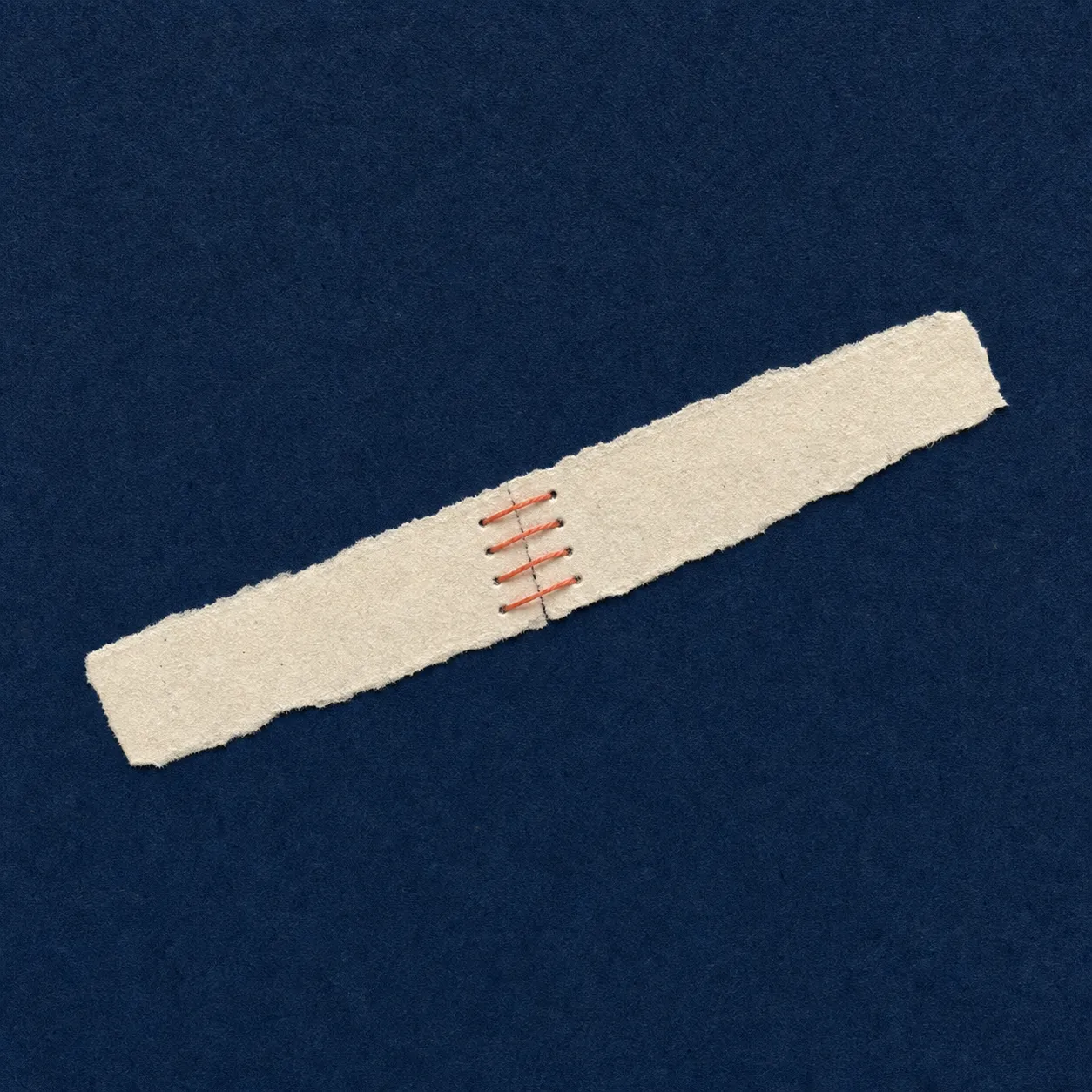 Two torn paper pieces stitched together with red thread on a dark blue background.