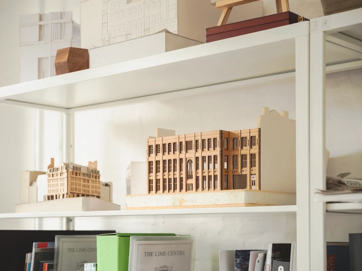 A photo of a facade model on a shelf in a warmly lit studio space.