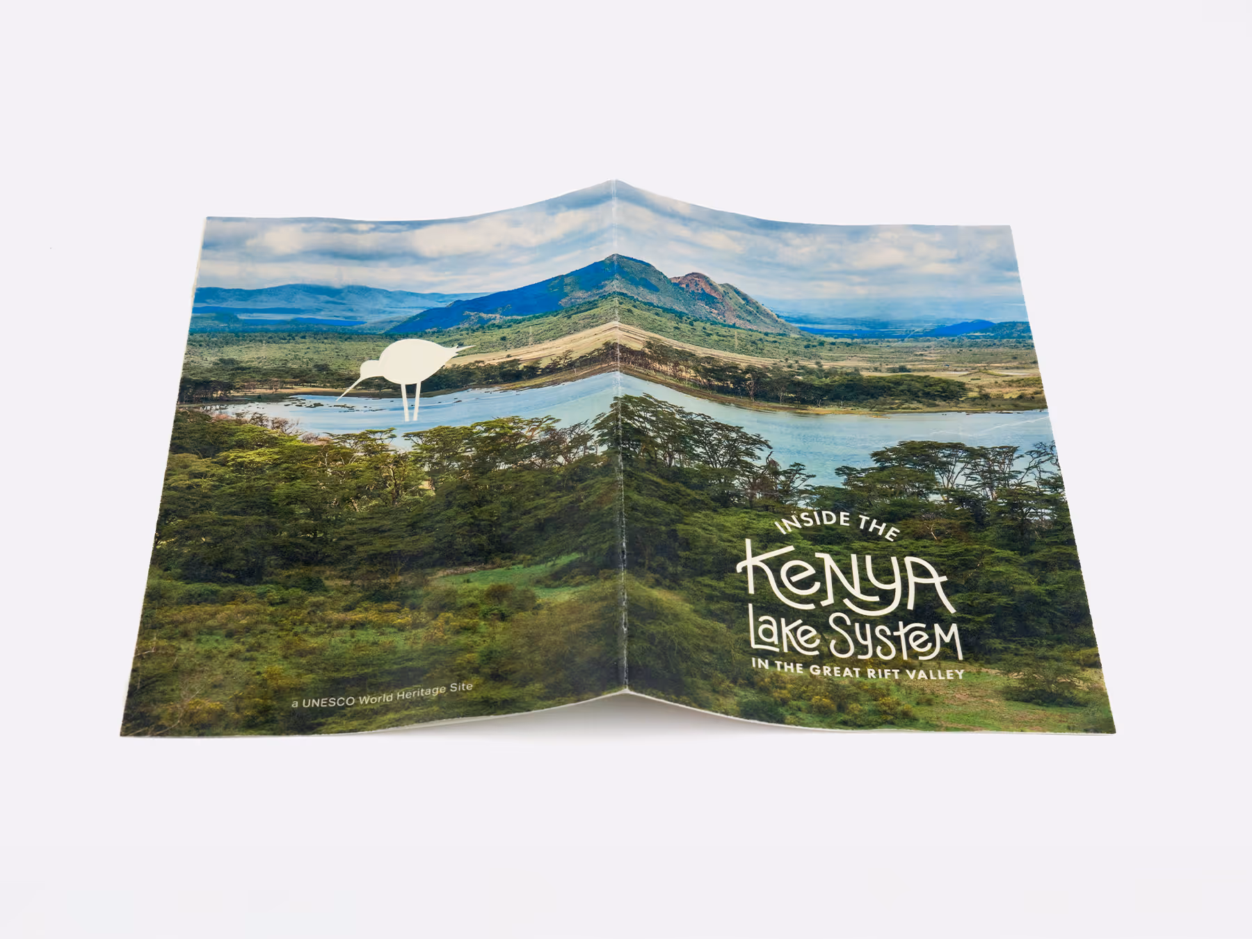 Open booklet with a scenic photo of a lake and mountain landscape and text reading Inside the Kenya Lake System in the Great Rift Valley.