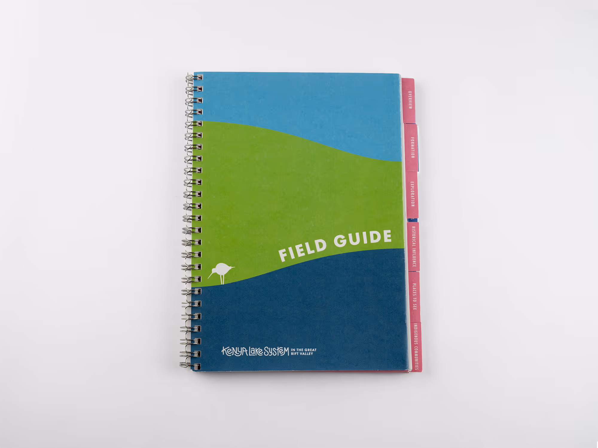 Spiral-bound field guide titled 'Kenya Lake System in the Great Rift Valley' with blue, green, and dark blue waves on the cover and pink tabs labeled Overview, Formation, Exploration, Historical Influence, Places to See, and Indigenous Communities.