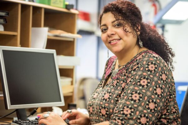 Roofing office manager sitting at her computer