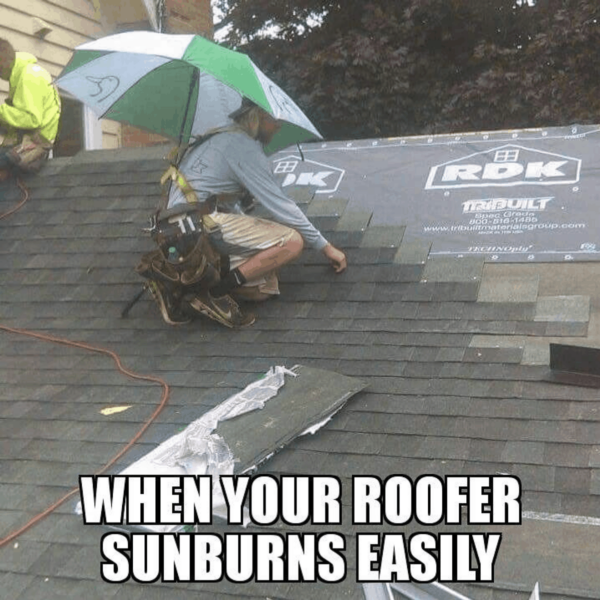 A roofer with an open umbrella strapped into his work belt to give him shade