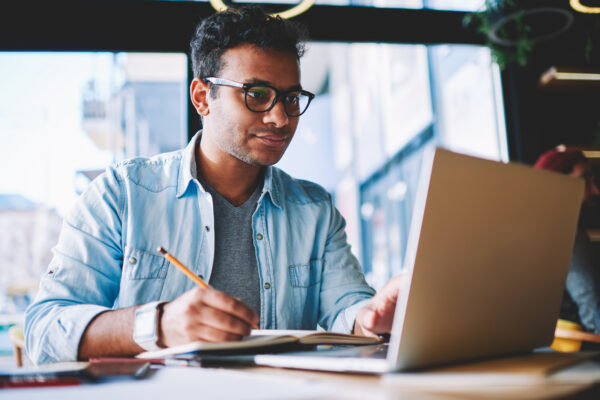 A man at a laptop creating a roofing business plan