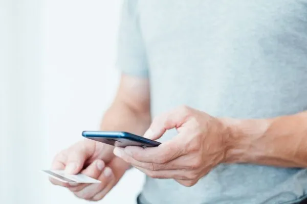 A customer paying a contractor with a credit card on their phone