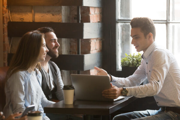 Roofing salesman with a laptop talking to a couple