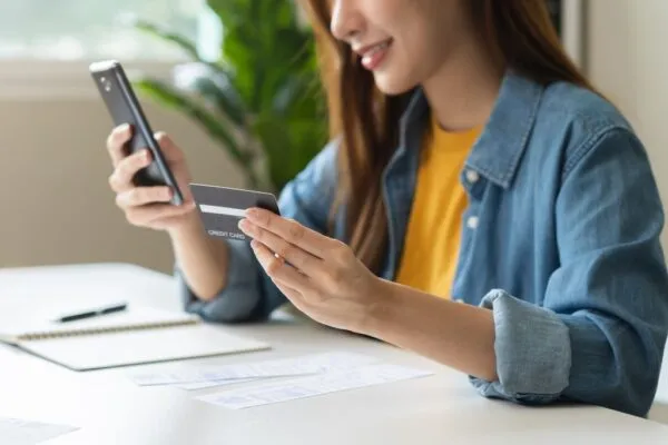 Woman paying on phone with a credit card