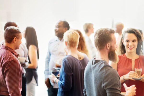 A large group of people networking at a roofing event