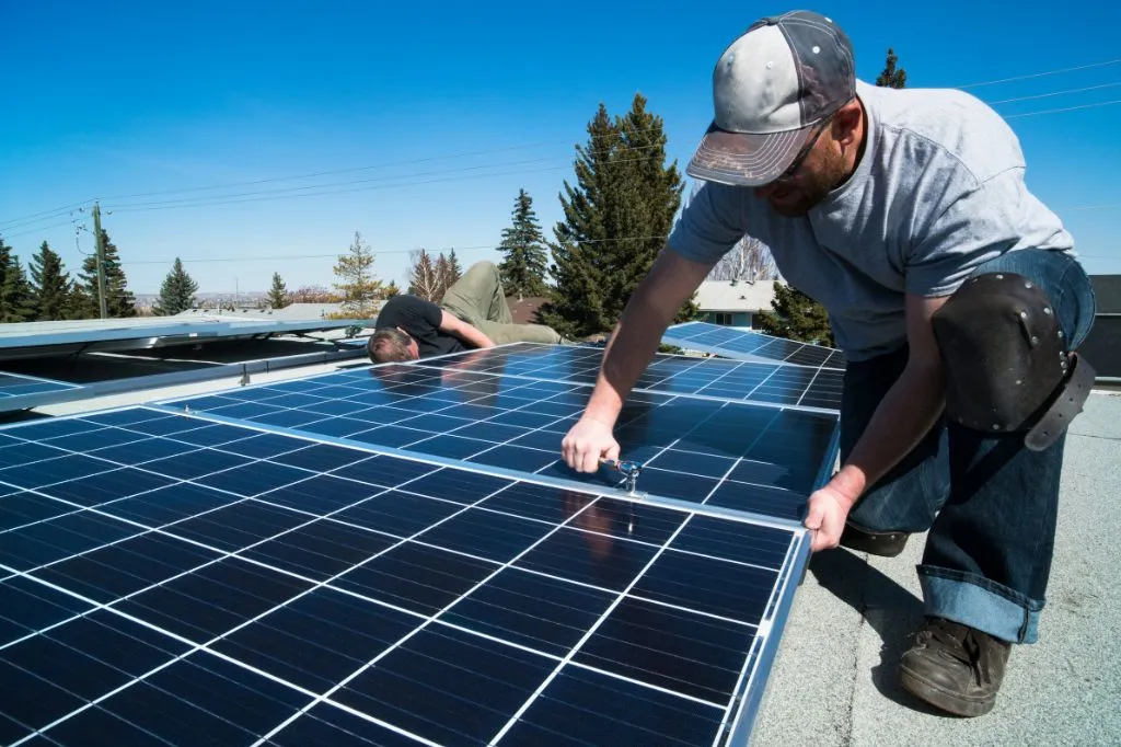 Roofers installing solar panels