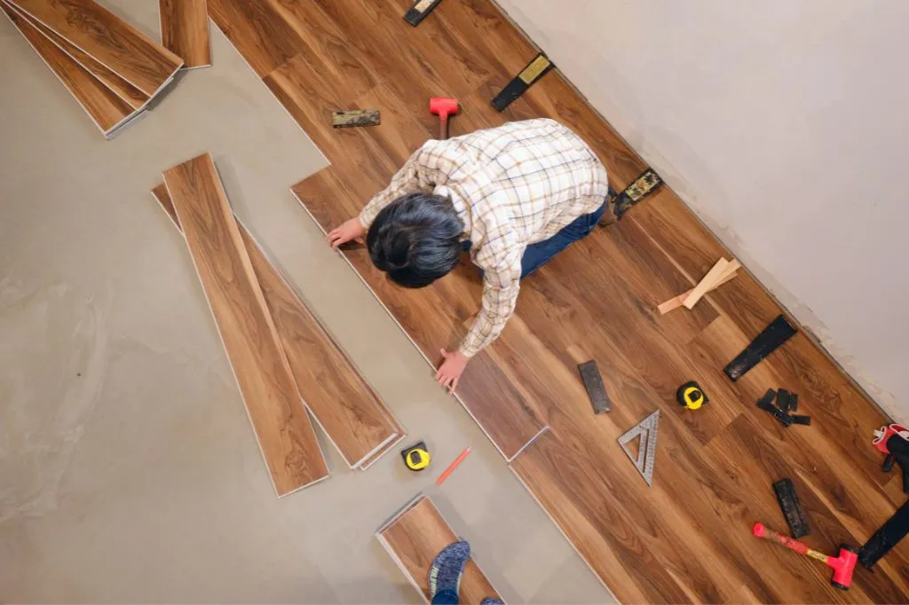 A roofer installing new flooring for a home remodeling project