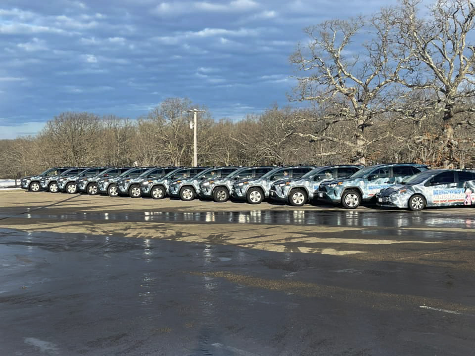 A whole fleet of roofing vehicles with vinyl wraps