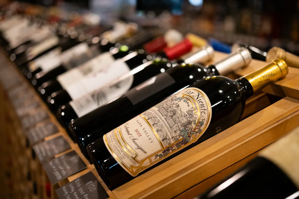 A row of wine bottles on a wooden wine rack
