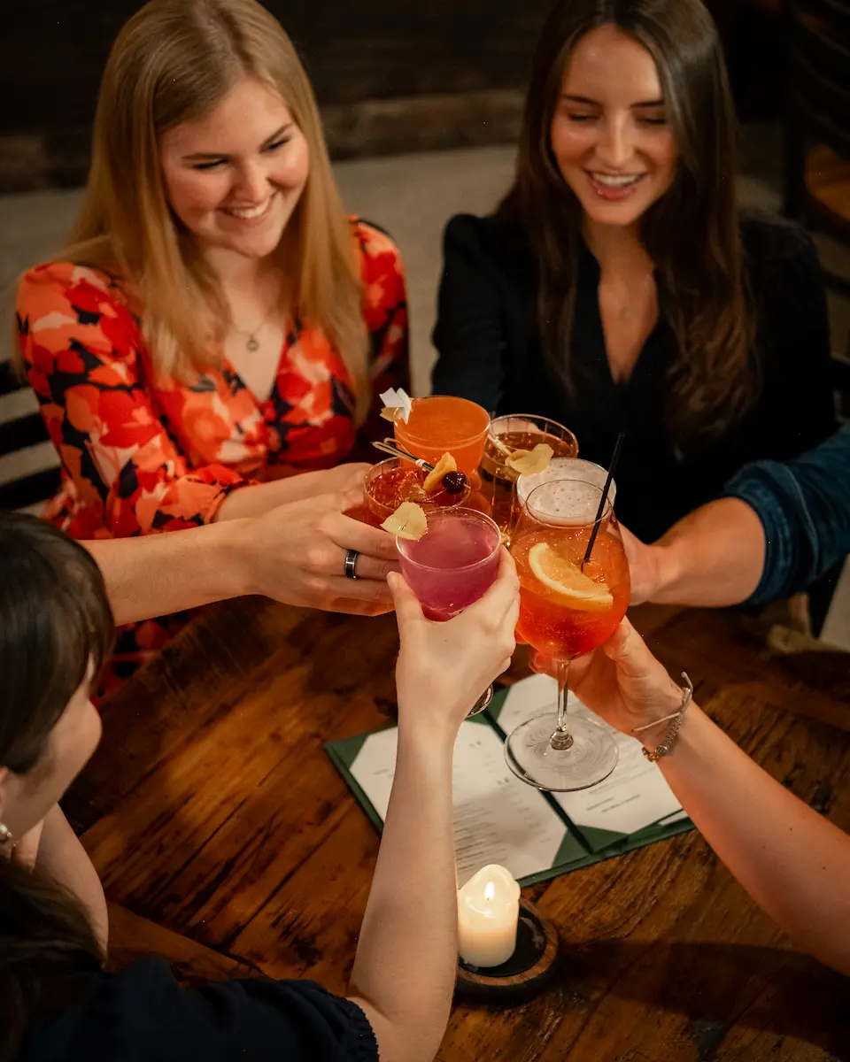 A group of patrons holding up their drinks