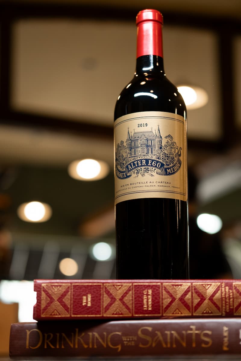 A bottle of wine sitting on books