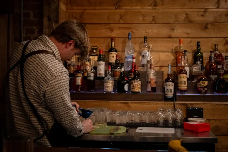 A bartender preparing drinks behind the Paradiso bar