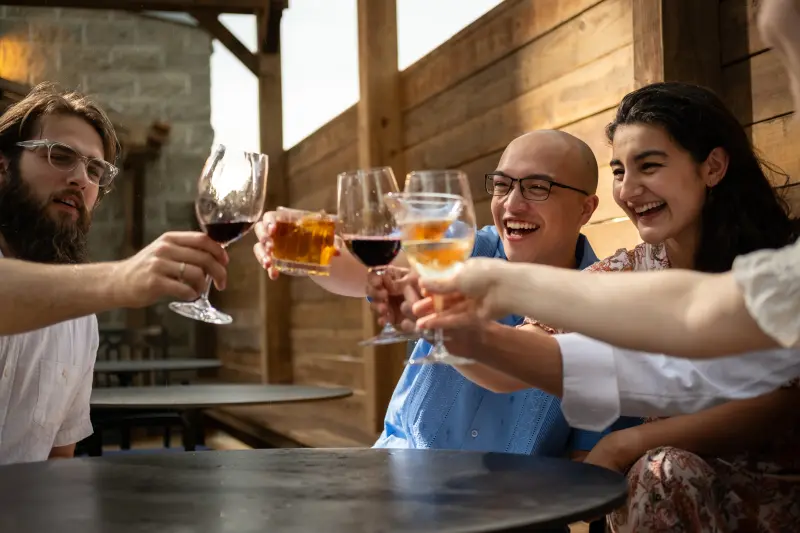 Friends raising glasses together on the Paradiso patio