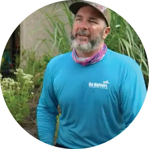 Erik Perna, co-owner of Go Native Landscaping, wearing a blue shirt and speaking about native landscaping practices.