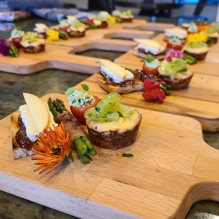 A tabletop with several serving boards including several hors d'oeuvres.