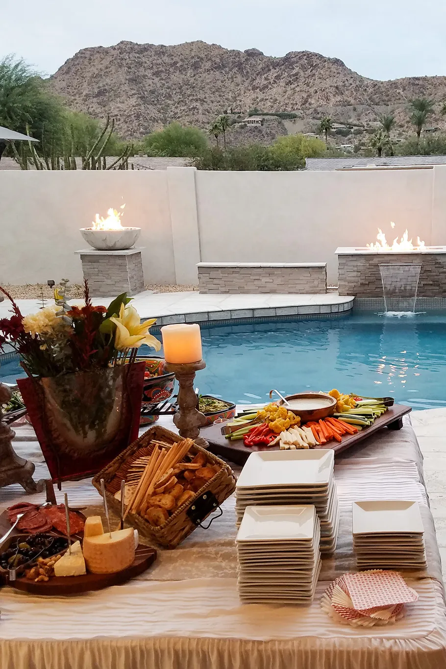 A bridal shower charcuterie spread set outside by the pool amongst the Arizona desert.