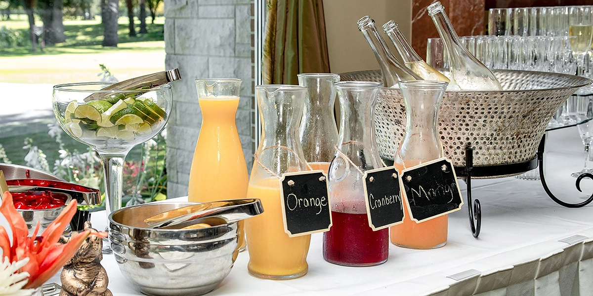 Guests at a Scottsdale brunch event enjoying a self-serve mimosa station with citrus garnishes and infused syrups.