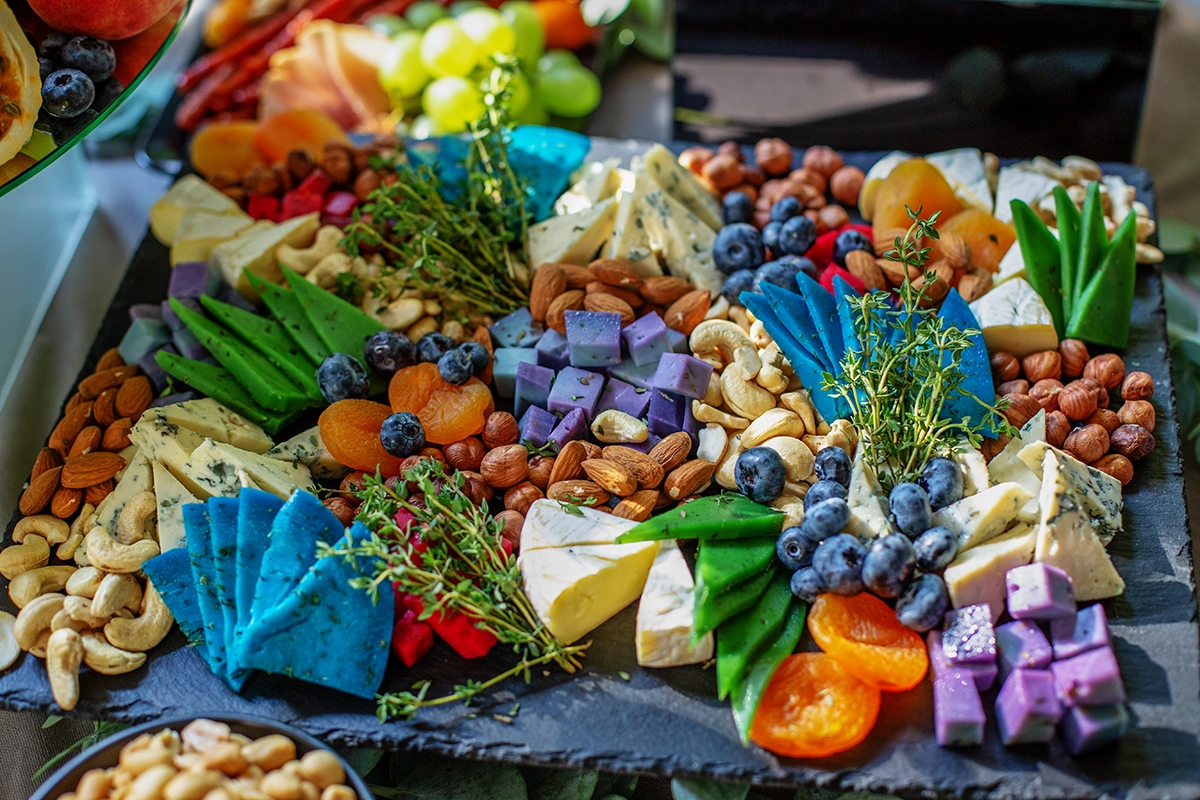 Color-coordinated brunch grazing board styled with fruits, cheeses, and edible flowers for a Scottsdale event.