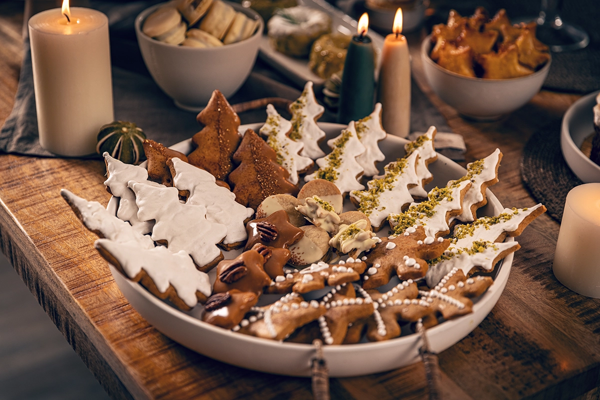 Holiday dessert display with mini peppermint chocolate tarts, Meyer lemon tartlets, and gingerbread cake on tiered stands
