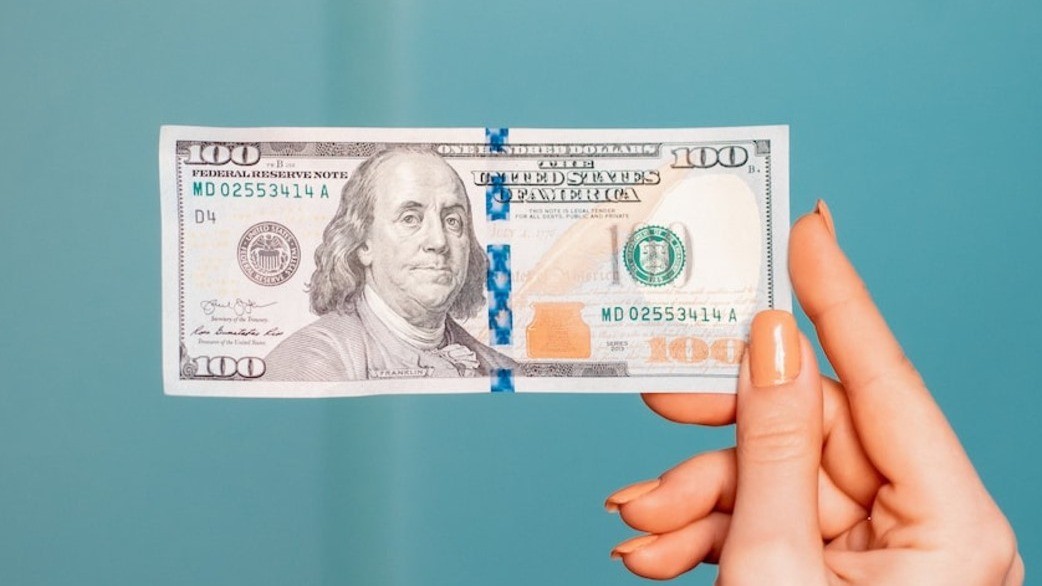 woman holding a 100 dollar bill - How to Trade Forex With $100