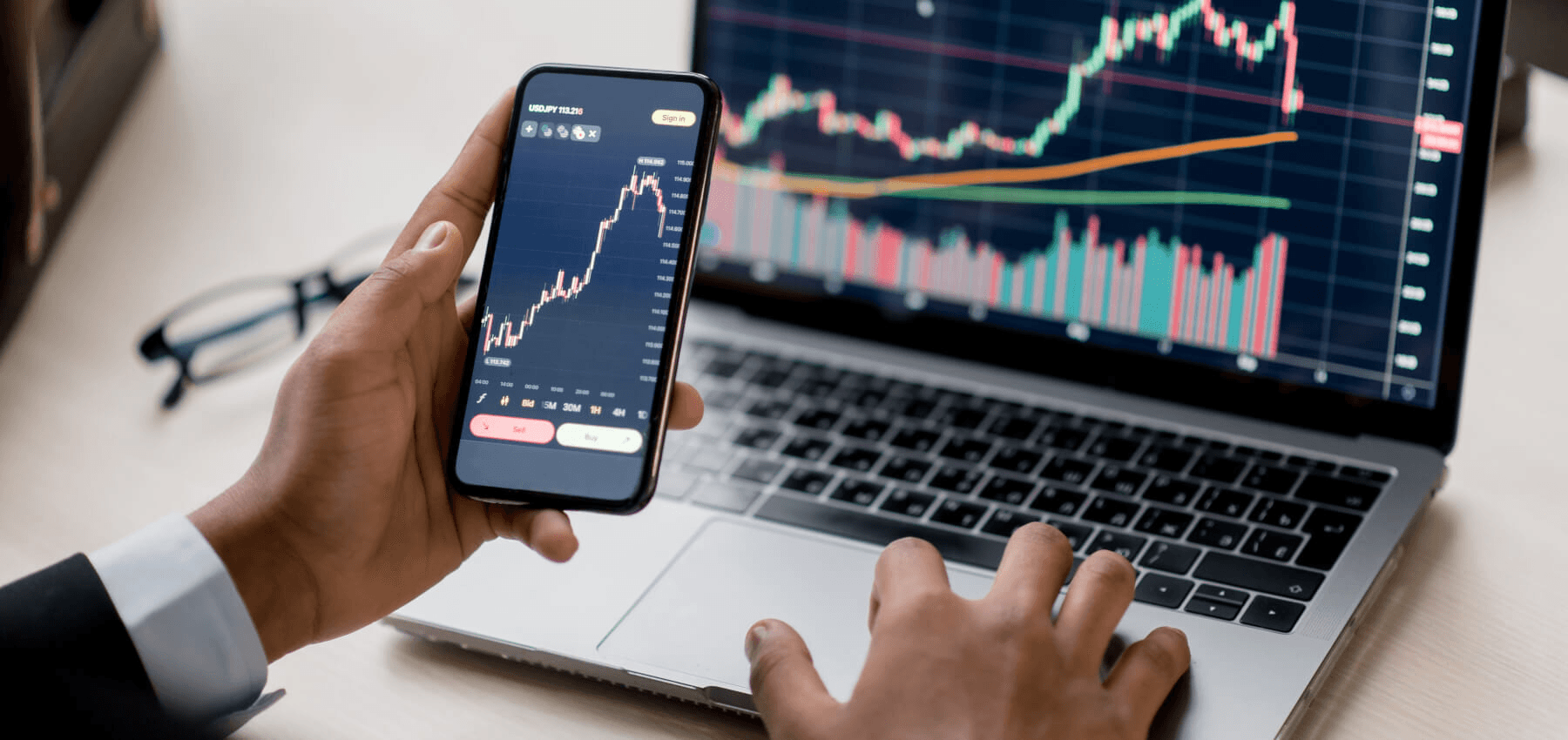 Person trading stocks on devices - How to Learn Stock Trading for Beginners