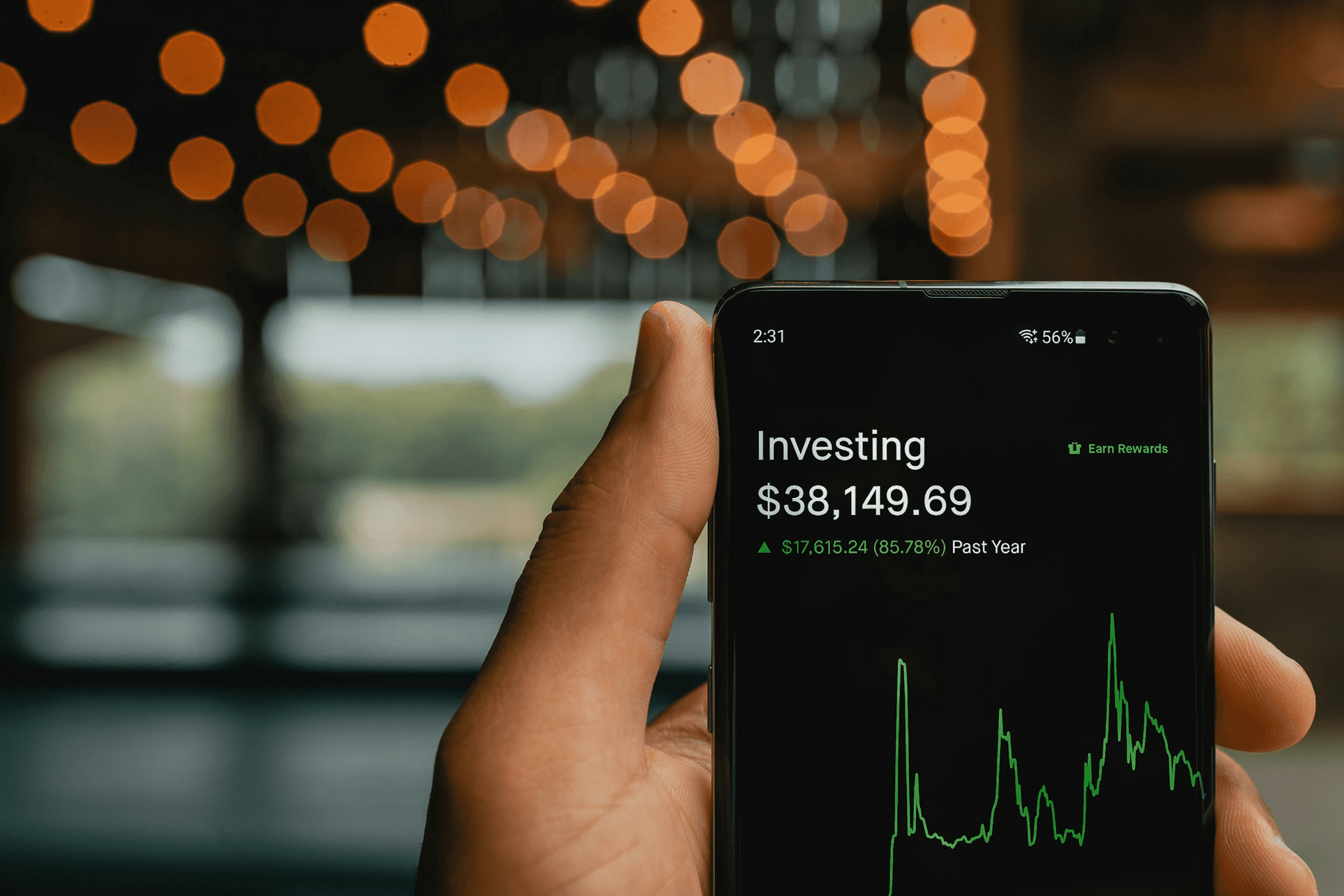 Person holding phone displaying investment gains - Proprietary Trading Firms in India